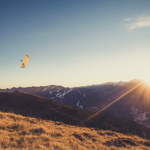 Paragleiter fliegen bei Sonnenuntergang.