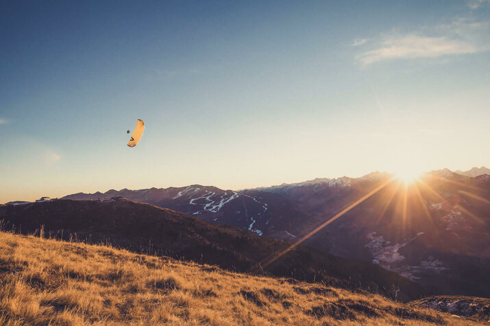 Paragleiter fliegen bei Sonnenuntergang.