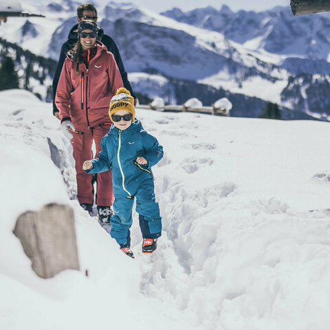 Ein Mann, eine Frau und ein Kind machen eine Spaziergang im Schnee