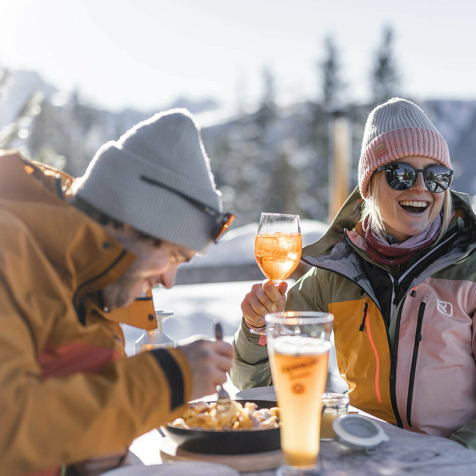 Ein Paar auf einer Hütte beim Trinken und Essen