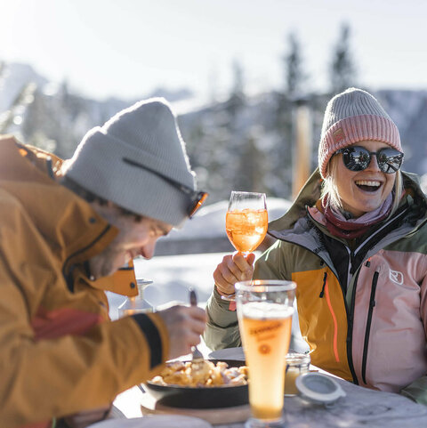 Ein Paar auf einer Hütte beim Trinken und Essen