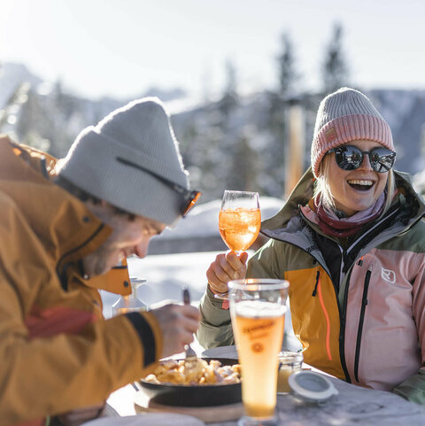 Ein Paar auf einer Hütte beim Trinken und Essen