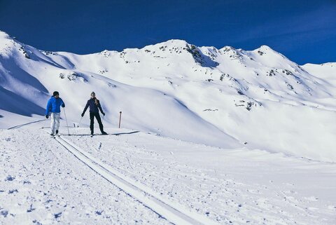 Zwei Langläufer auf einer verschneiten Strecke
