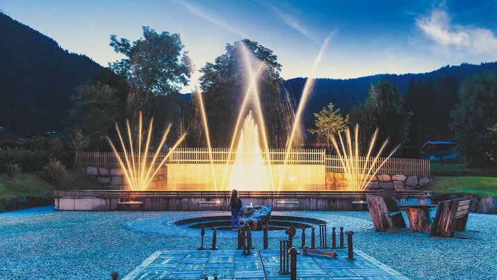 Abends beobachten Zuschauer Wasserfontänen, die in die Luft schießen