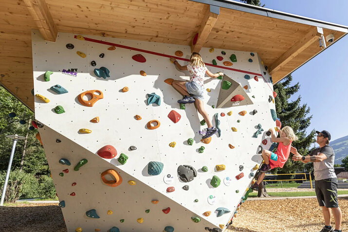 Zwei Kinder auf einer Kletterwand im Freizeitpark.