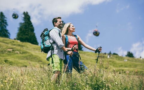 Ein Mann und eine Frau stehen auf einer Wiese und blicken in die Natur