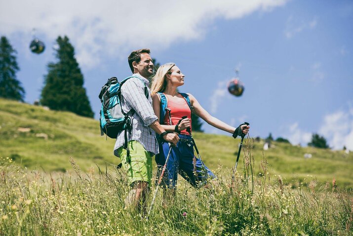 Ein Mann und eine Frau stehen auf einer Wiese und blicken in die Natur