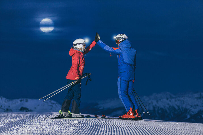 Zwei Skifahrer beim Nachtskifahren