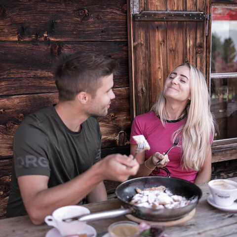 Ein Mann und eine Frau teilen sich einen Kaiserschmarrn