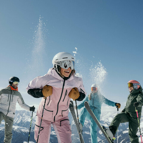Vier Skifahrer drei haben einen Skier in der Luft