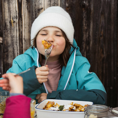 Ein Kind isst Kaiserschmarren