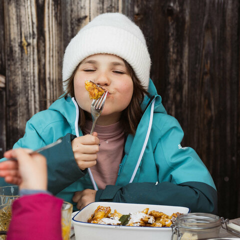 Ein Kind isst Kaiserschmarren