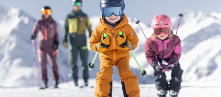 Eine Familie beim Skifahren die Kinder fahren Schuss
