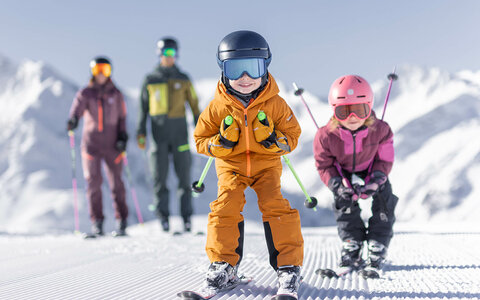 Eine Familie beim Skifahren die Kinder fahren Schuss