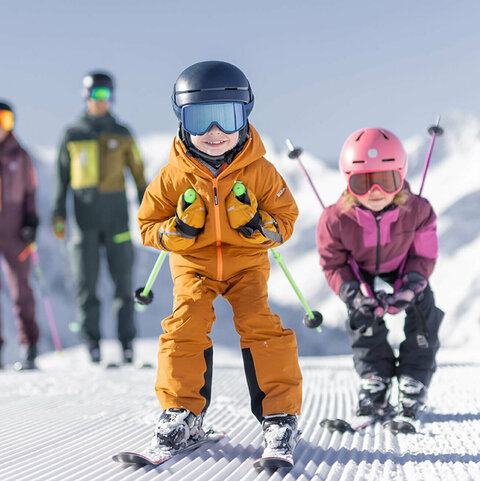 Eine Familie beim Skifahren die Kinder fahren Schuss