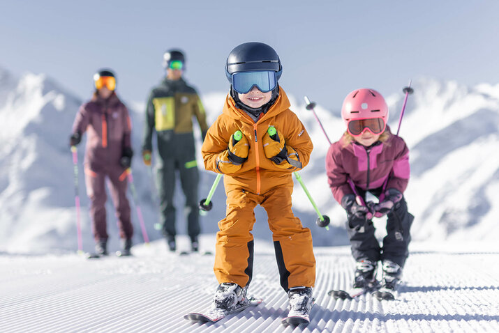 Eine Familie beim Skifahren die Kinder fahren Schuss