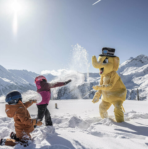 Zwei Kinder machen eine Schneeballschlacht gegen FUNTy in einer Winterkulisse