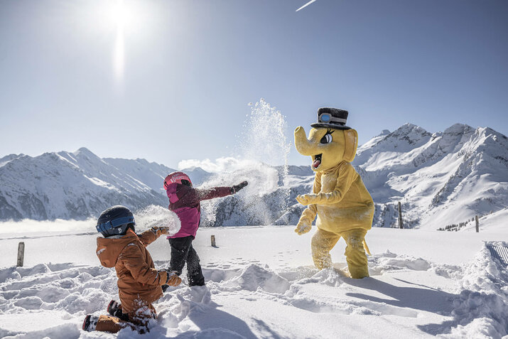 Zwei Kinder machen eine Schneeballschlacht gegen FUNTy in einer Winterkulisse