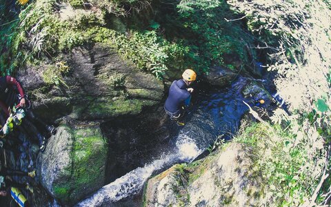 Ein Person springt ins Wasser beim Canyoning.