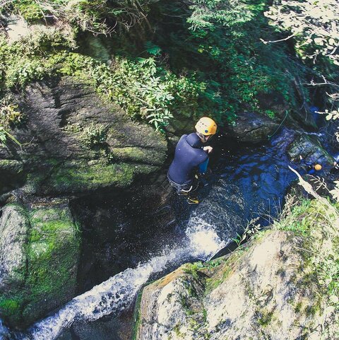 Ein Person springt ins Wasser beim Canyoning.