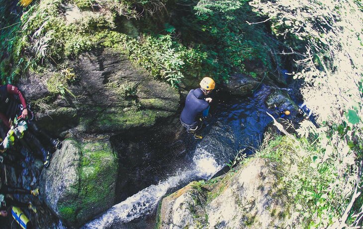 Ein Person springt ins Wasser beim Canyoning.