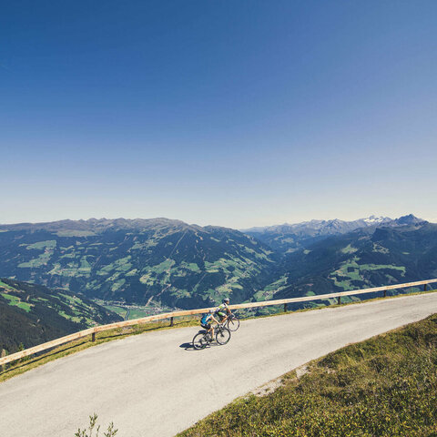 Zwei Radfahrer fahren vor einer traumhaften Bergkulisse