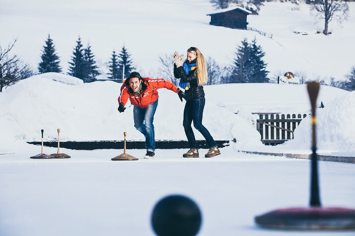 Ein Mann und eine Frau beim Eisstockschiessen