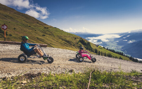 Ein Mann und ein Mädchen fahren mit Mountain Carts