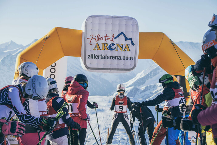 Skifahrer stehen am Pistenstart und warten auf ihren Start