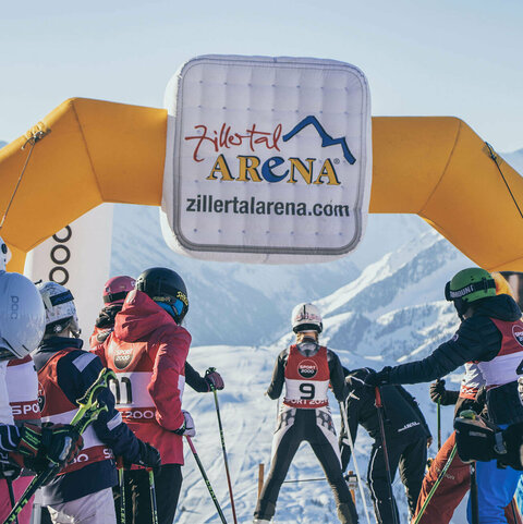 Skifahrer stehen am Pistenstart und warten auf ihren Start