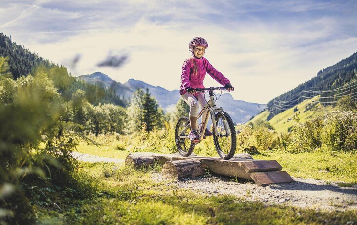 Ein Mädchen fährt auf einem Mountainbike durch den Wald