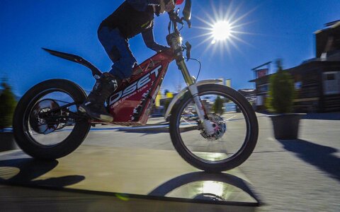 Ein Junge fährt mit einem E-Trial-Bike über einen Parcours
