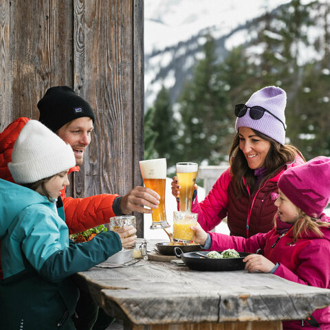 Eine Familie beim Mittagessen auf einer Hütte
