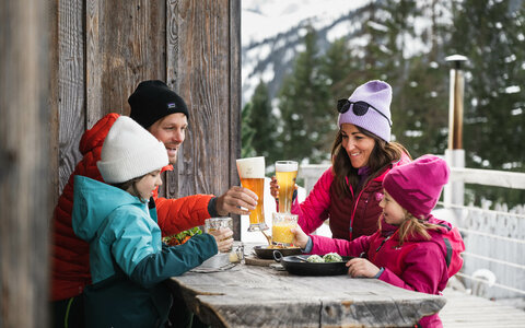 Eine Familie beim Mittagessen auf einer Hütte