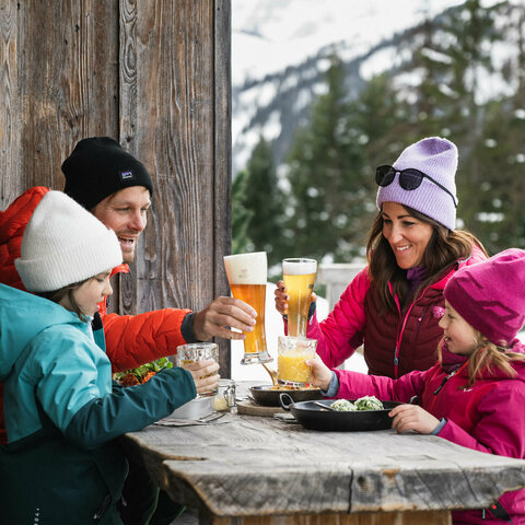 Eine Familie beim Mittagessen auf einer Hütte