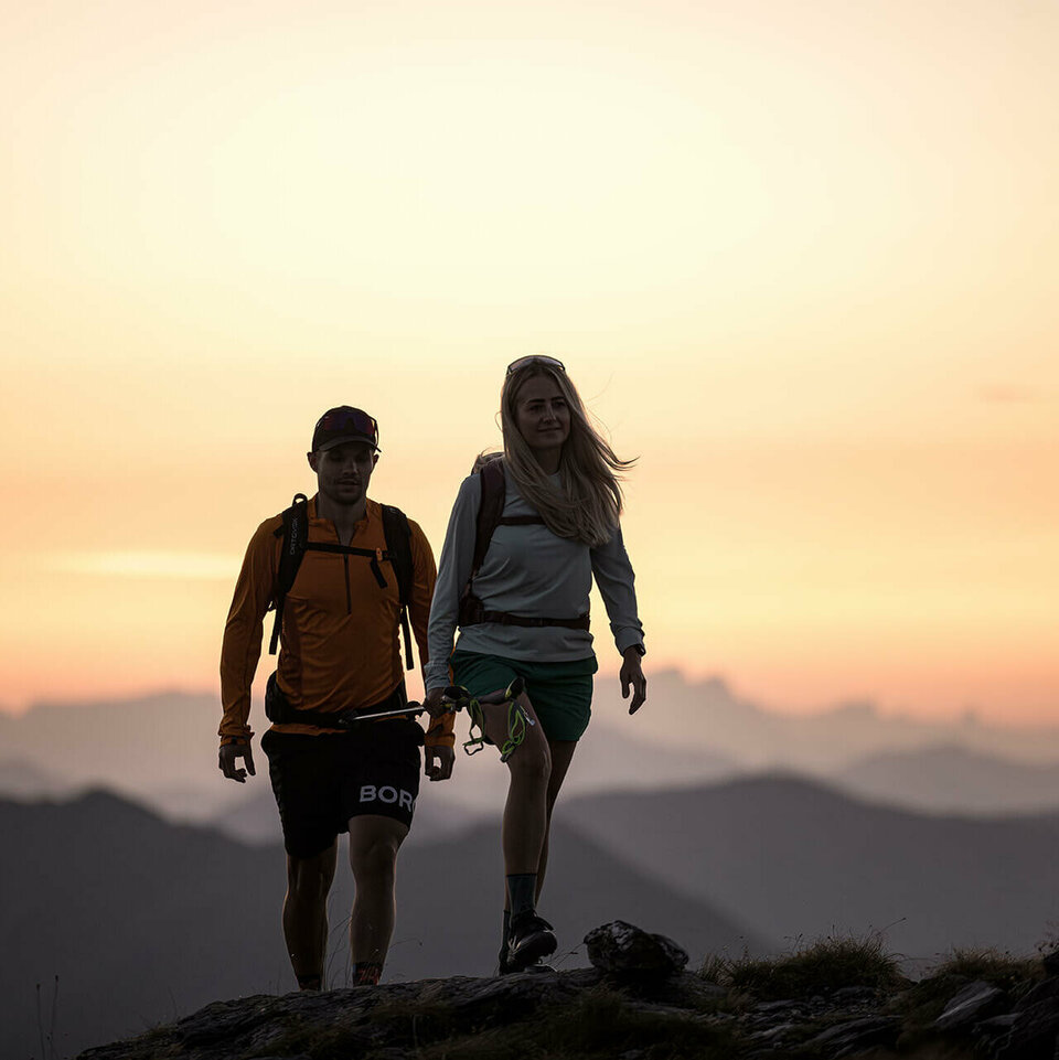 Ein Mann und eine Frau wandern beim Sonnenaufgang