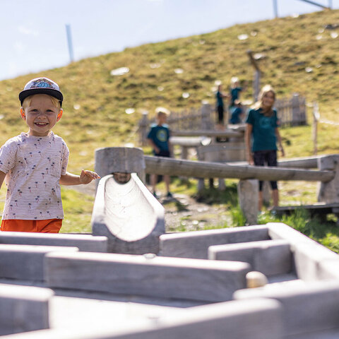 Kinder spielen mit einer Holzkugelbahn